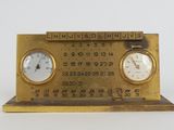 two clocks on a brass clock stand with numbers on it