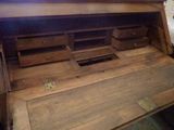 a wooden desk with drawers and a clock on top of it