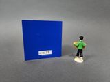 a small figurine that is standing next to a blue book