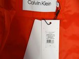 an orange jacket with a name tag on it and a tag attached to it