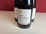 three bottles of wine are sitting on a table in front of a red wall