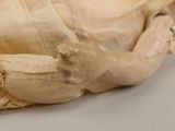 a close up of a doll laying on a table