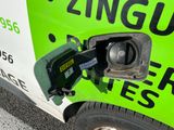 a green and white truck with a gas pump attached to it ' s side