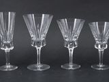 four wine glasses are lined up on a black surface