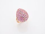 une bague sertie d'un diamant rose et d'un diamant blanc, posée sur un fond blanc