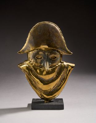 une statue en or représentant un homme portant un chapeau et une écharpe