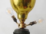 a gold lamp that is on top of a black base
