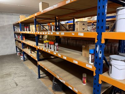 many shelves with buckets and cans of paint on them