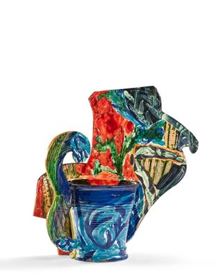 un vase coloré posé sur une surface blanche