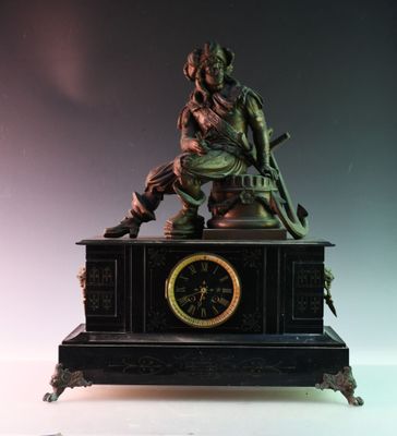 une statue d'un homme assis au sommet d'une horloge