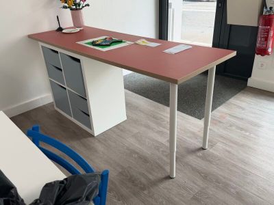 un bureau dans un coin d'une pièce, avec une chaise bleue devant