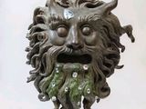 a statue of a man with a beard and a green face