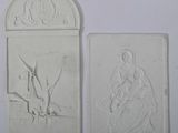 two white reliefs of a woman and a man on a boat