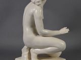 statue of a woman kneeling on a marble base