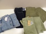 Plusieurs paires de jeans sont disposées sur une surface blanche