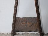 un petit tabouret en bois avec une assise sculptée