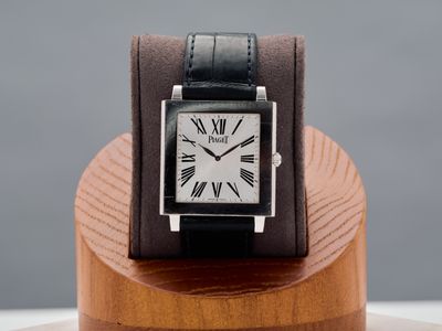 a watch that is sitting on top of a wooden stand
