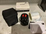 un objectif d'appareil photo, un étui pour appareil photo et quelques autres objets posés sur une table