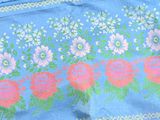 a blue table cloth with pink and green flowers on it