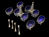 several silver and blue glass dishes and spoons on a black background