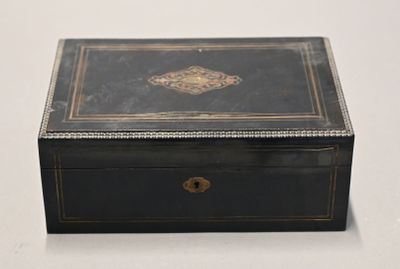 an old black box with a gold decoration on the lid