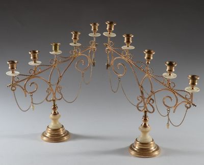 pair of antique brass candelabs with candles on each of them