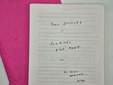 un morceau de papier rose sur lequel est écrit à la main un poème
