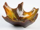 a brown and green bowl on a white surface