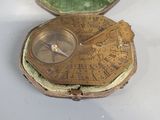 a small gold pocket with a compass inside of it