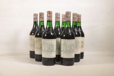 six bouteilles de vin sont alignées sur une surface blanche