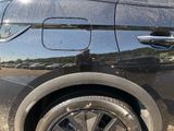 a cat sitting on the rim of a black car