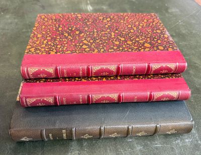 trois livres sont empilés sur une table