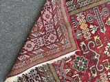 a close up of a red rug on the ground