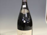une bouteille de vin posée sur un comptoir à côté d'un verre de vin