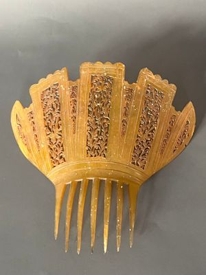 a yellow hair comb that is shaped like a fan