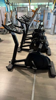 a row of stationary exercise bikes in a gym