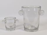 two clear glass vases with handles and handles sitting next to each other