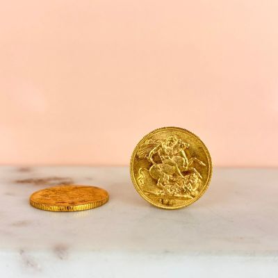 a gold coin sitting on top of a marble counter next to a gold coin