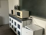 two microwaves and a refrigerator in a small room
