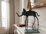 a statue of an elephant on a mantle in a room