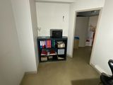 a room with a desk, chair, and television in it