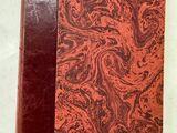un vieux livre à la couverture rouge posé sur une table