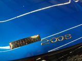 a close up of a shiny blue car with a number plate on it