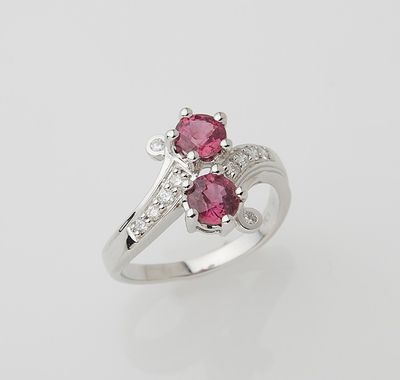 a white gold ring with two pink sapphires and diamonds