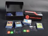 une boîte contenant des cartes et des dés, posée sur une table