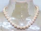 pearl necklace on a mannequin neck with a white background