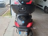 a motor scooter parked in a garage with a van in the background