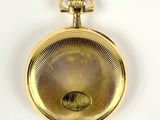 a gold pocket watch on a white surface