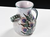 a vase with a flower design on it sitting on a table