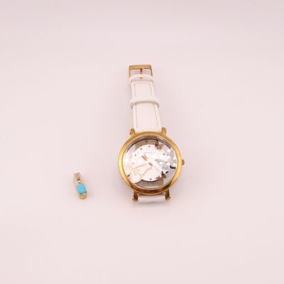 une montre et une brosse à dents posées sur une surface blanche